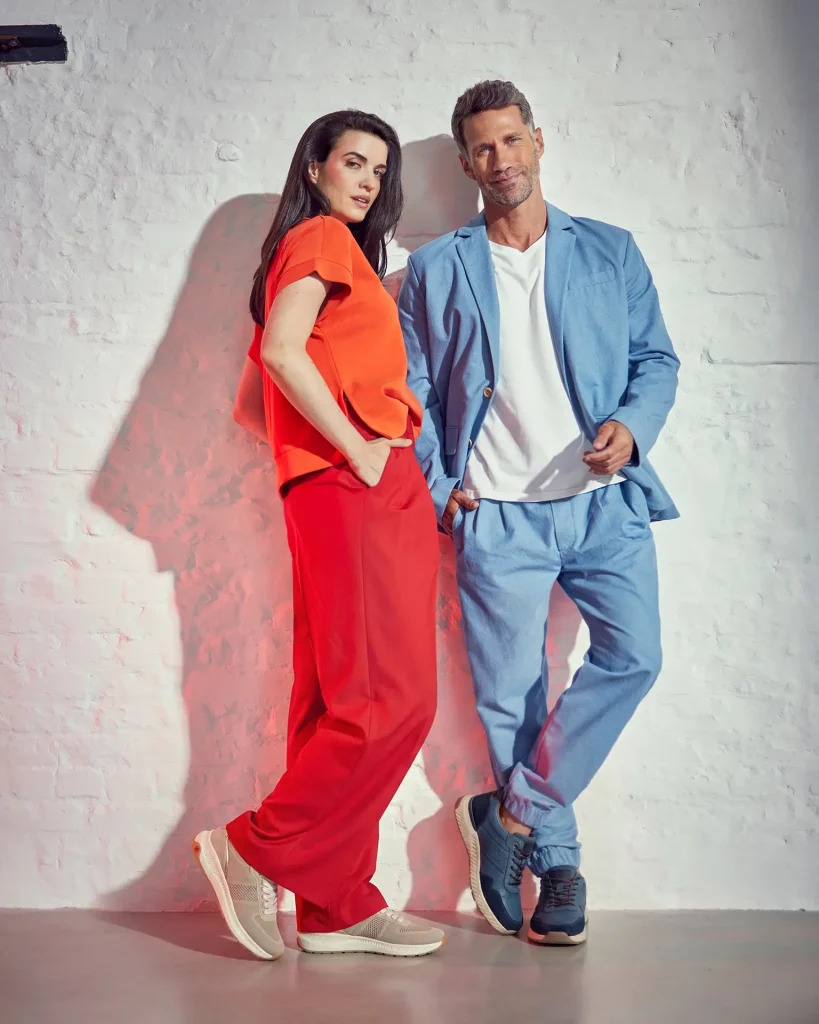 Frau in rotem Outfit und Mann im blauen Anzug tragen Relife Schuhe